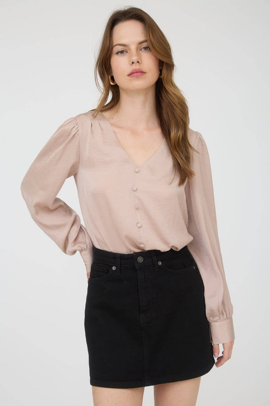 Woman wearing a beige blouse and black skirt on a white background
