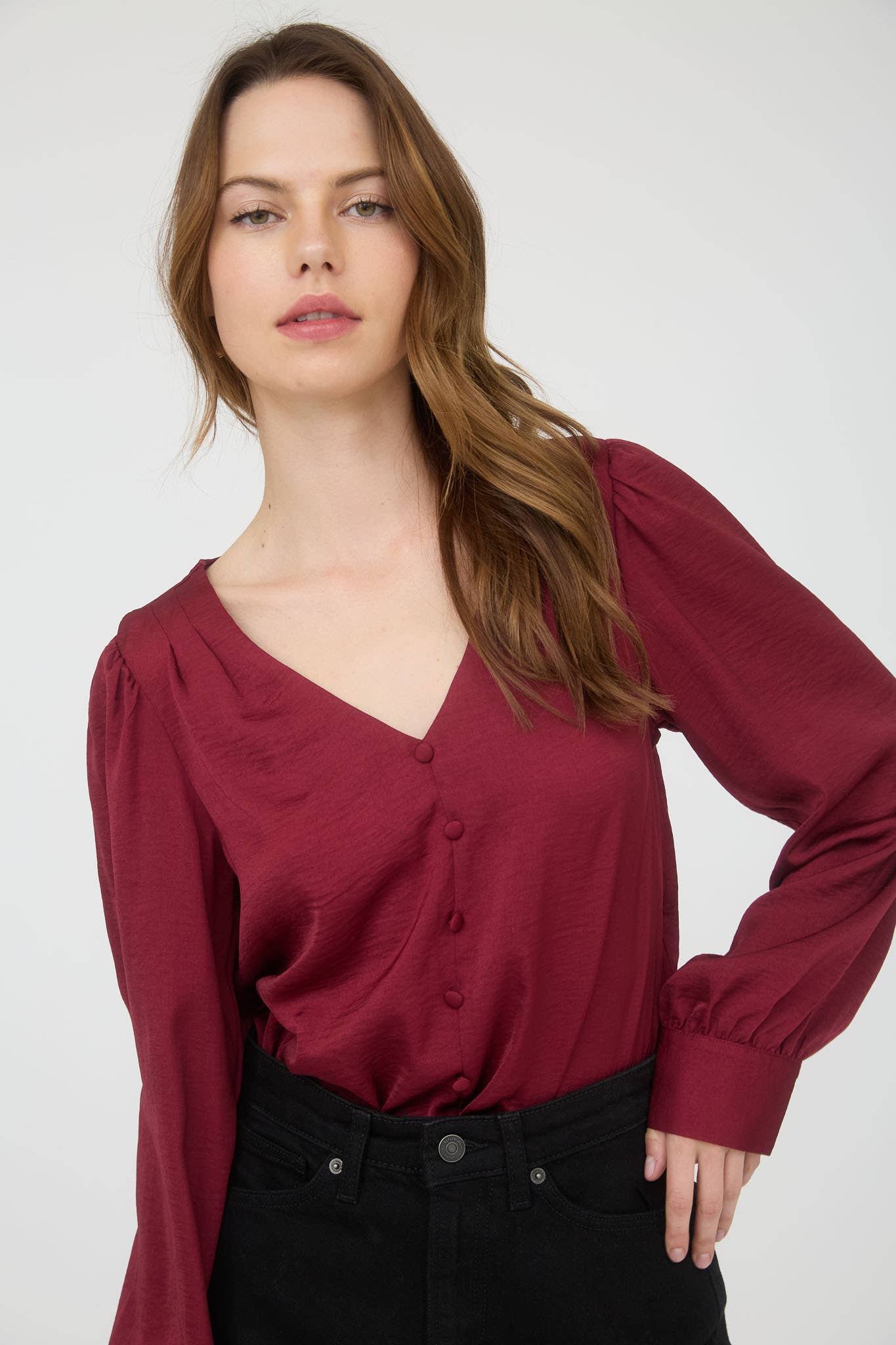 Woman wearing a burgundy blouse against a white background