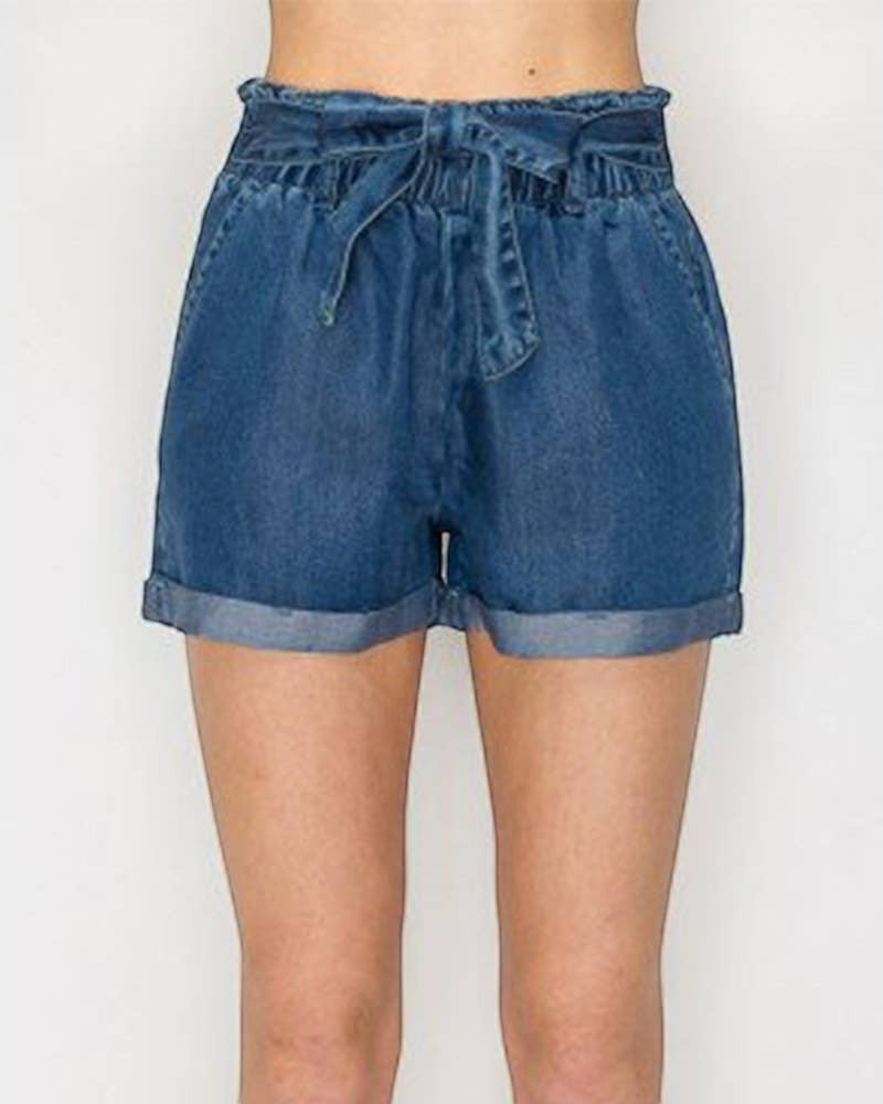 Blue denim shorts worn by a person on a white background