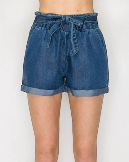Blue denim shorts worn by a person on a white background