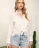 Woman wearing a white blouse and denim shorts with a cactus plant in the background
