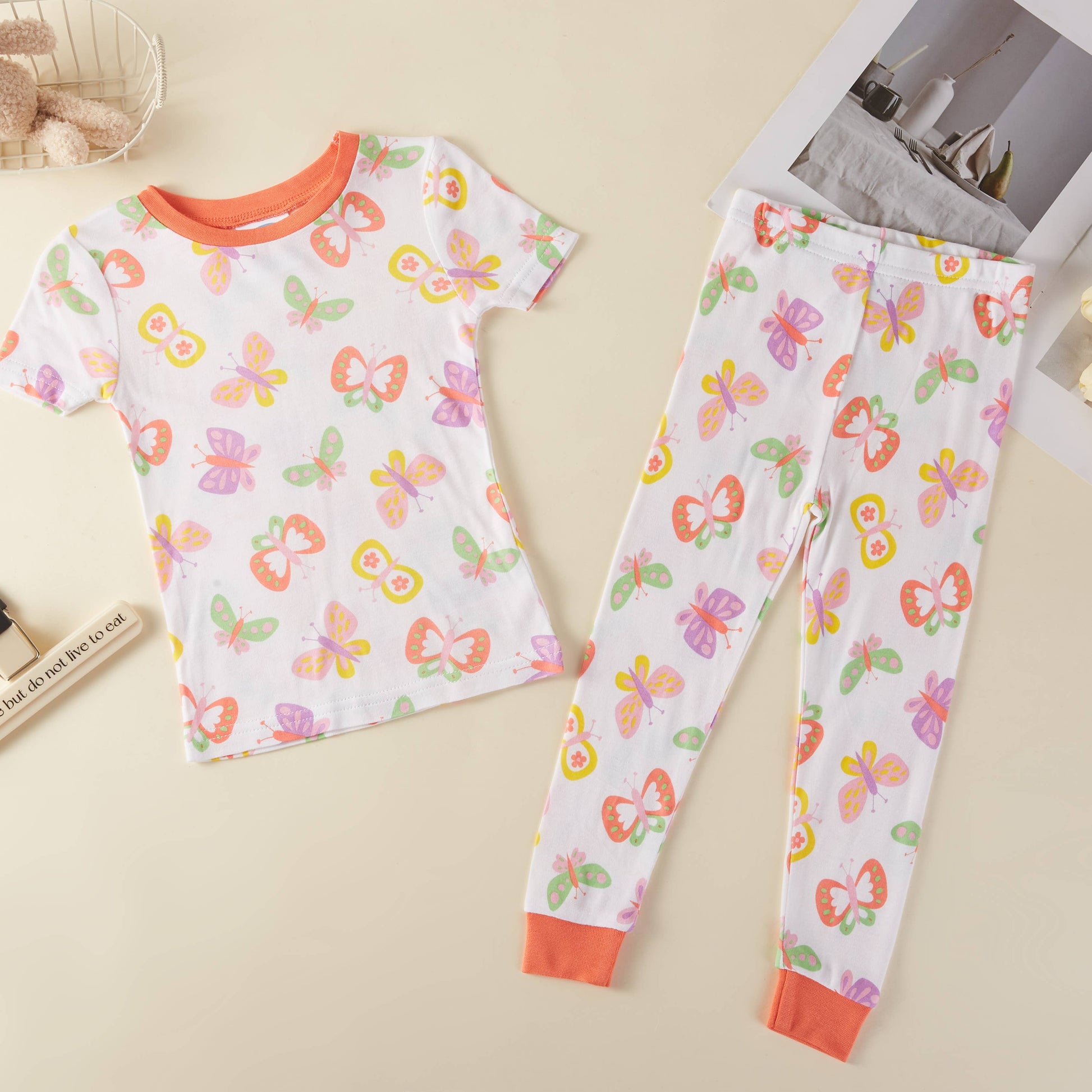 Children's pajama set with butterfly pattern on a beige surface