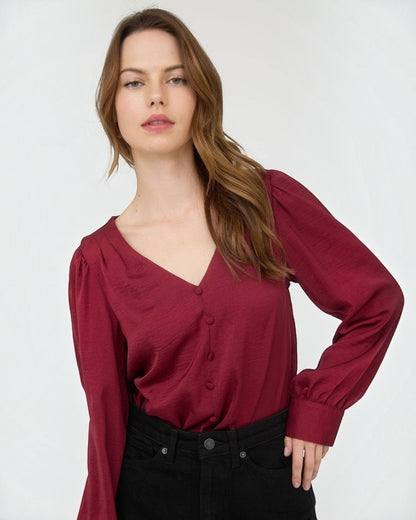 Woman wearing a burgundy blouse against a white background