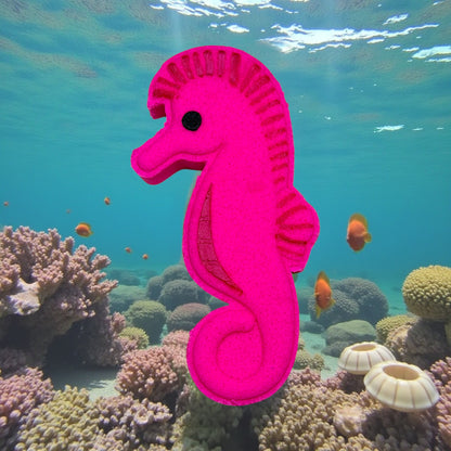 Pink seahorse toy in an underwater scene with coral and fish