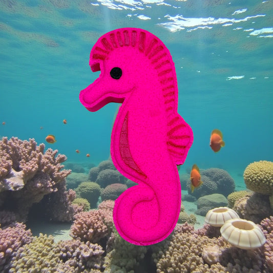Pink seahorse toy in an underwater scene with coral and fish