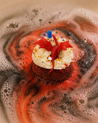 Cupcake with dragon decoration in a swirling red and black liquid