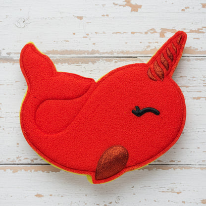 Red narwhal-shaped patch on pebbles
