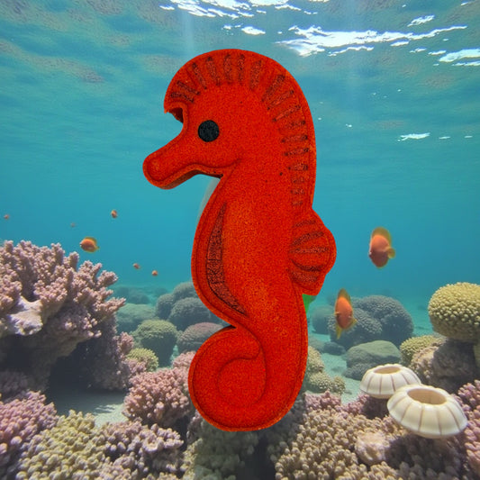 Red seahorse bath bomb on a coral reef with fish and sunlight filtering through water.