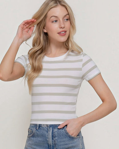 Woman wearing a striped shirt and jeans against a plain background