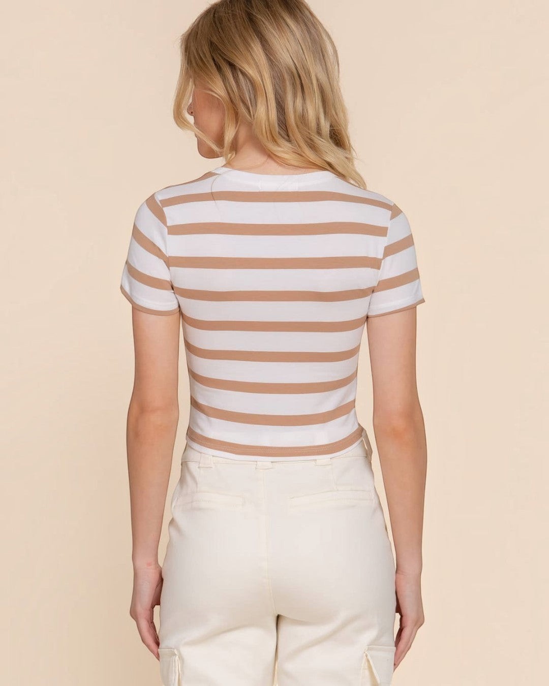 Woman wearing a striped shirt and pants on a beige background