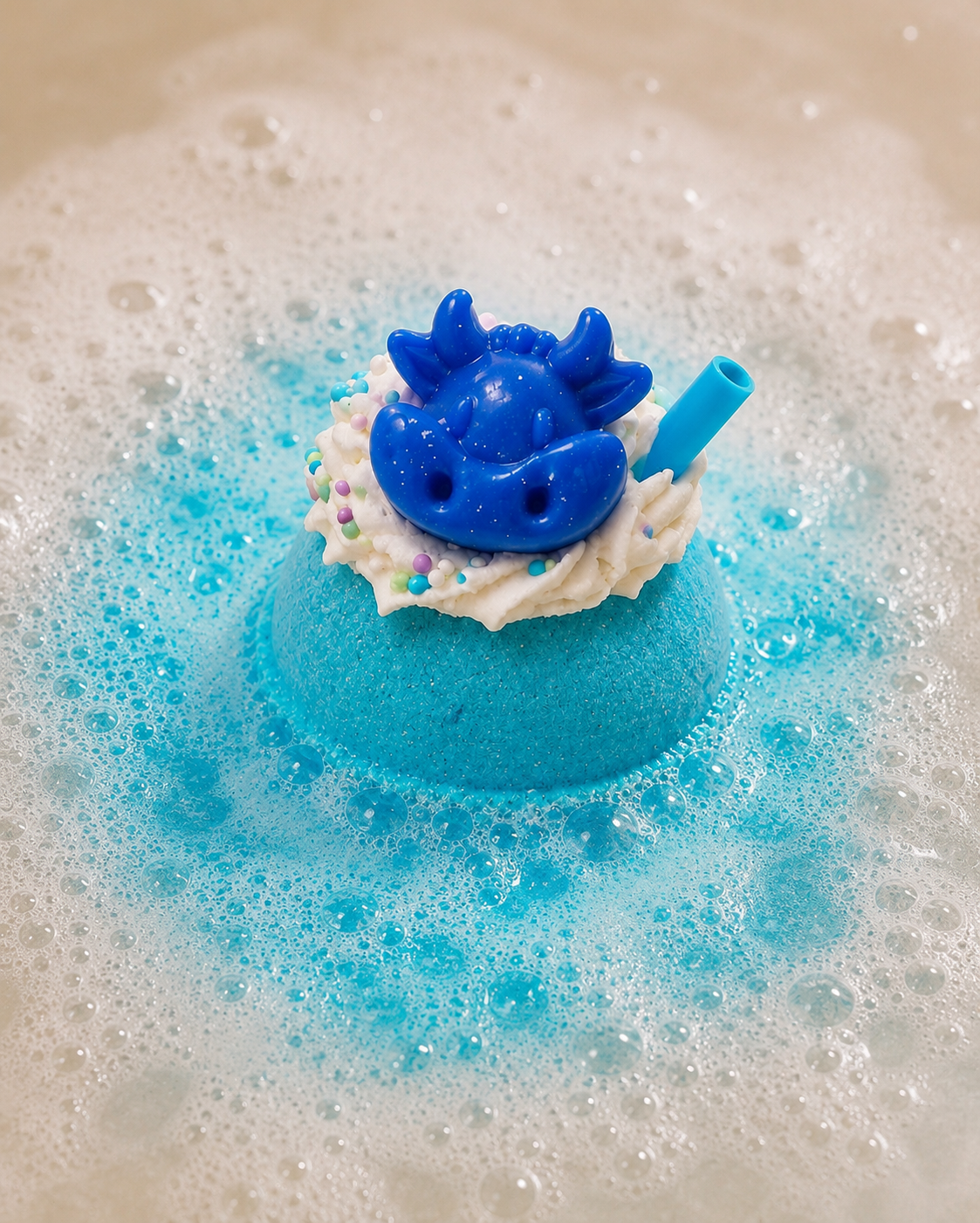 Blue toy with a shell and starfish on top of a blue foam block in soapy water.
