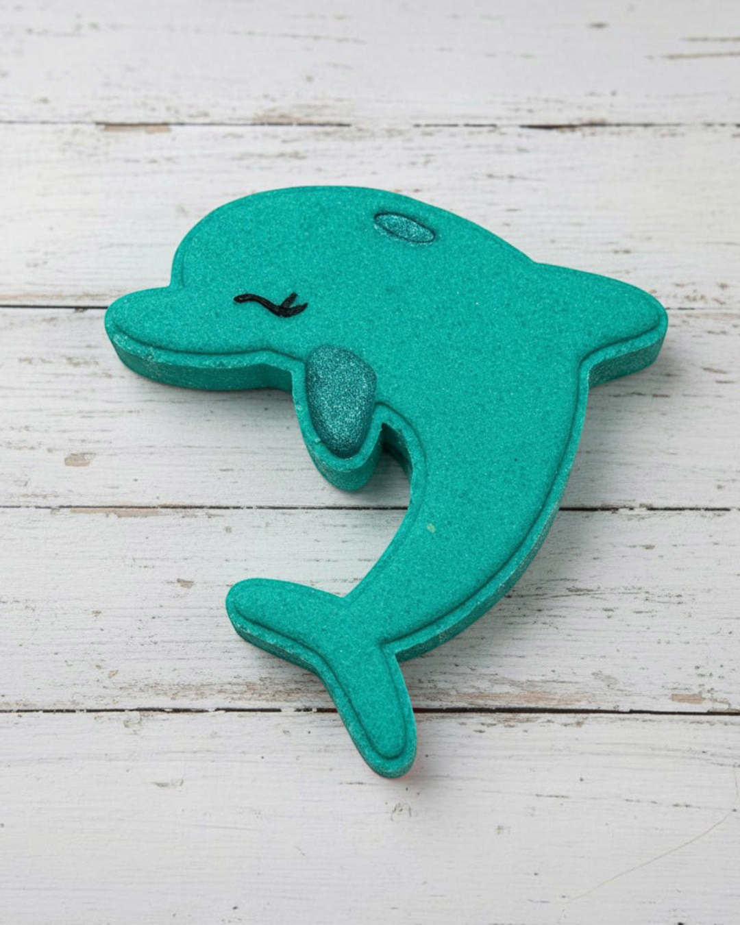 Teal dolphin-shaped object on a white background