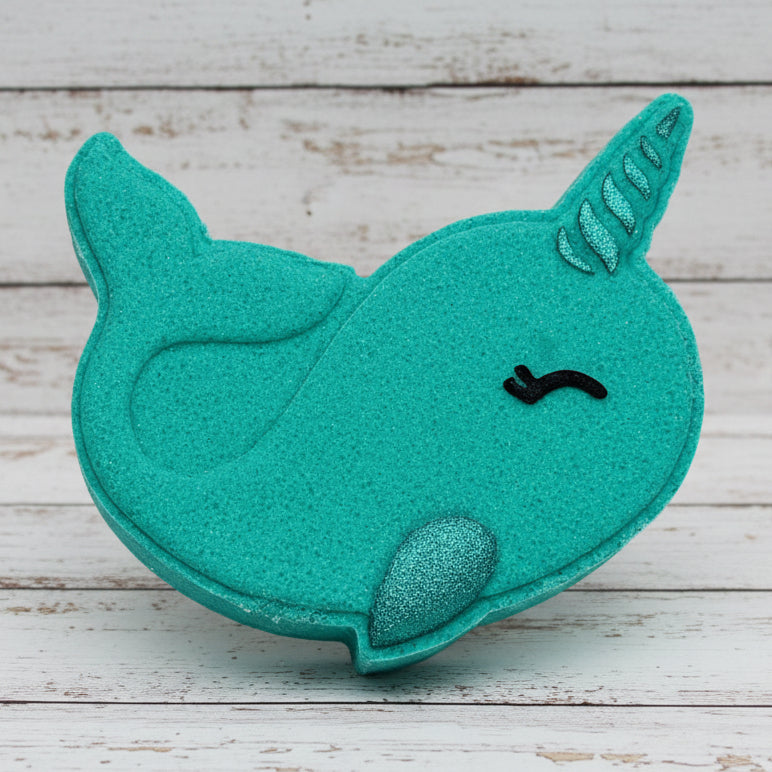 Turquoise narwhal-shaped object on pebbles