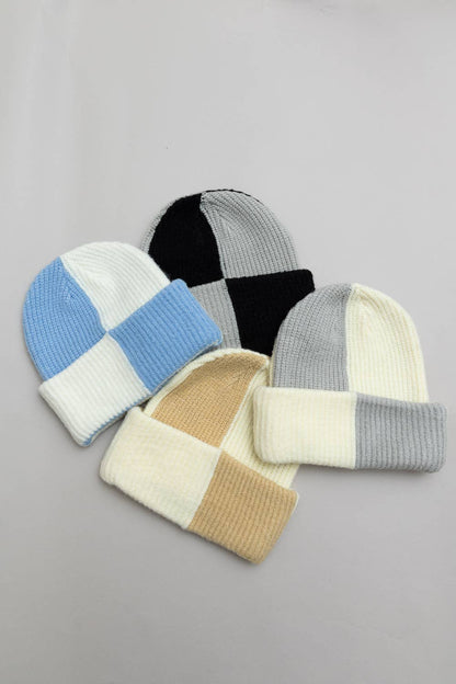 Four patchwork-style beanies in different color combinations on a gray background