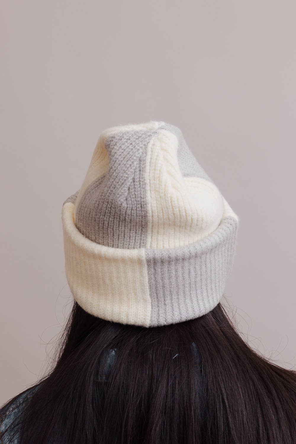 Patchwork knit beanie on a mannequin head against a plain background