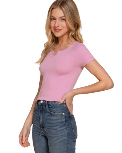 Woman wearing a pink top and blue jeans on a beige background