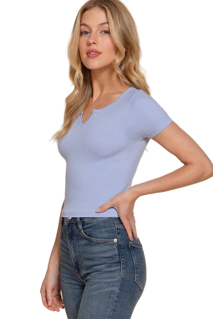 Woman wearing a light blue top and jeans on a beige background