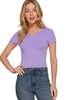 Woman wearing a purple top and blue jeans on a beige background