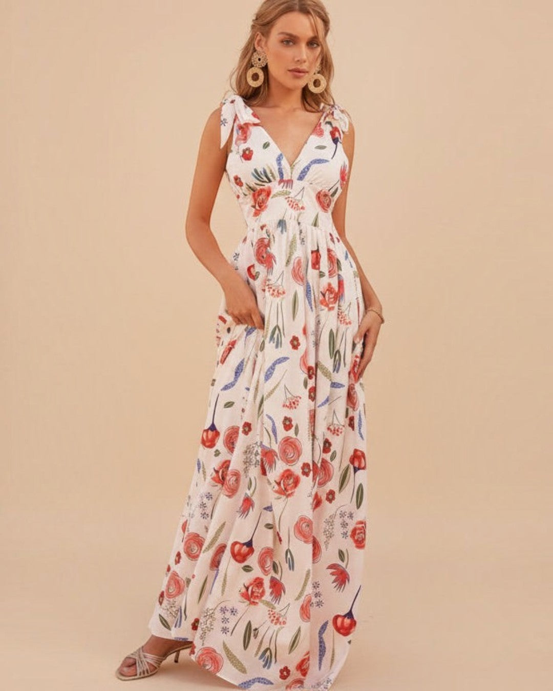 Woman wearing a floral dress against a white wall