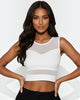 Woman wearing a white mesh top against a light background
