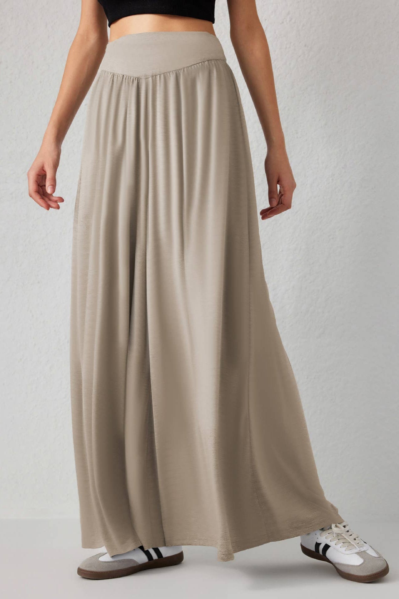 Beige long skirt worn by a person on a plain background
