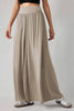 Beige long skirt worn by a person on a plain background