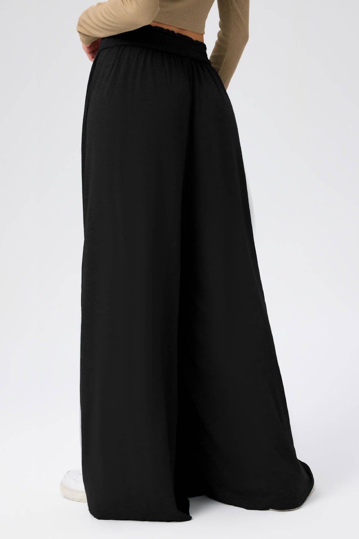 Black wide-leg pants worn by a person on a white background
