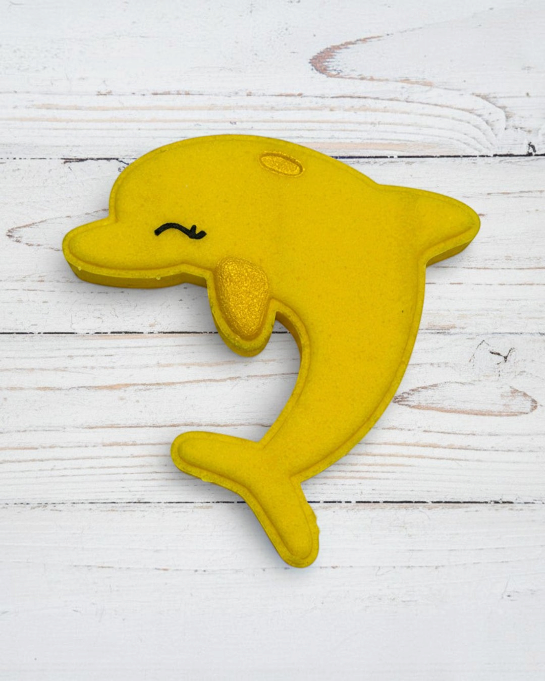 Yellow dolphin-shaped toy on a white background